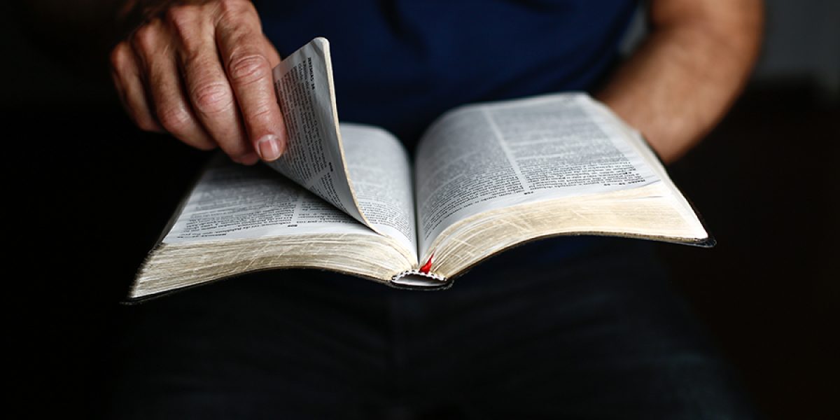 A man opening the bible with his hands