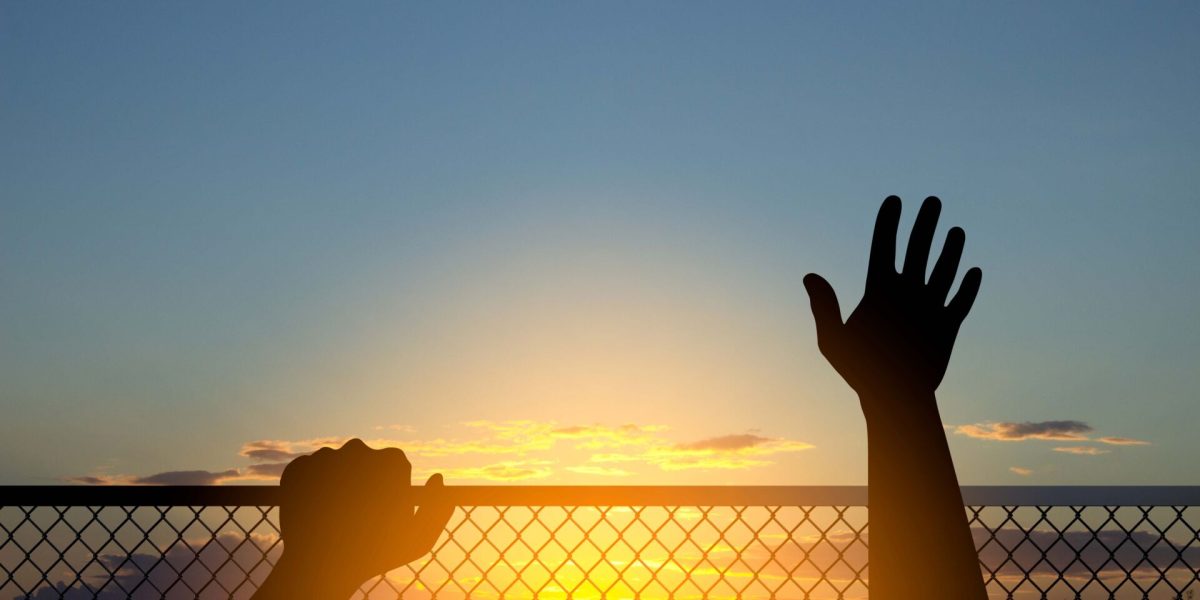 Silhouette of a human hands on chain link fence. 3d-rendering