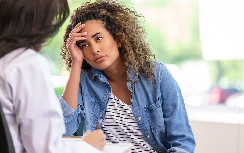 Worried patient consults with a mental health professional about emotional distress during a private therapy session.