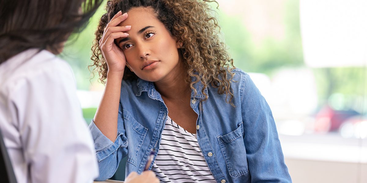 Worried patient consults with a mental health professional about emotional distress during a private therapy session.